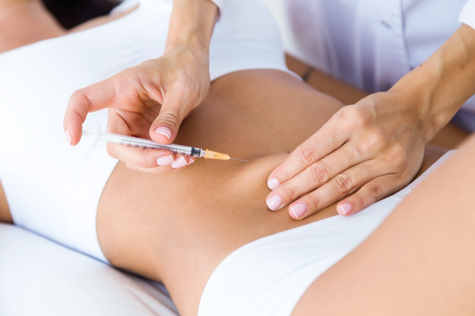 A supervised GLP-1 injection being administered into the abdomen by a licensed healthcare professional