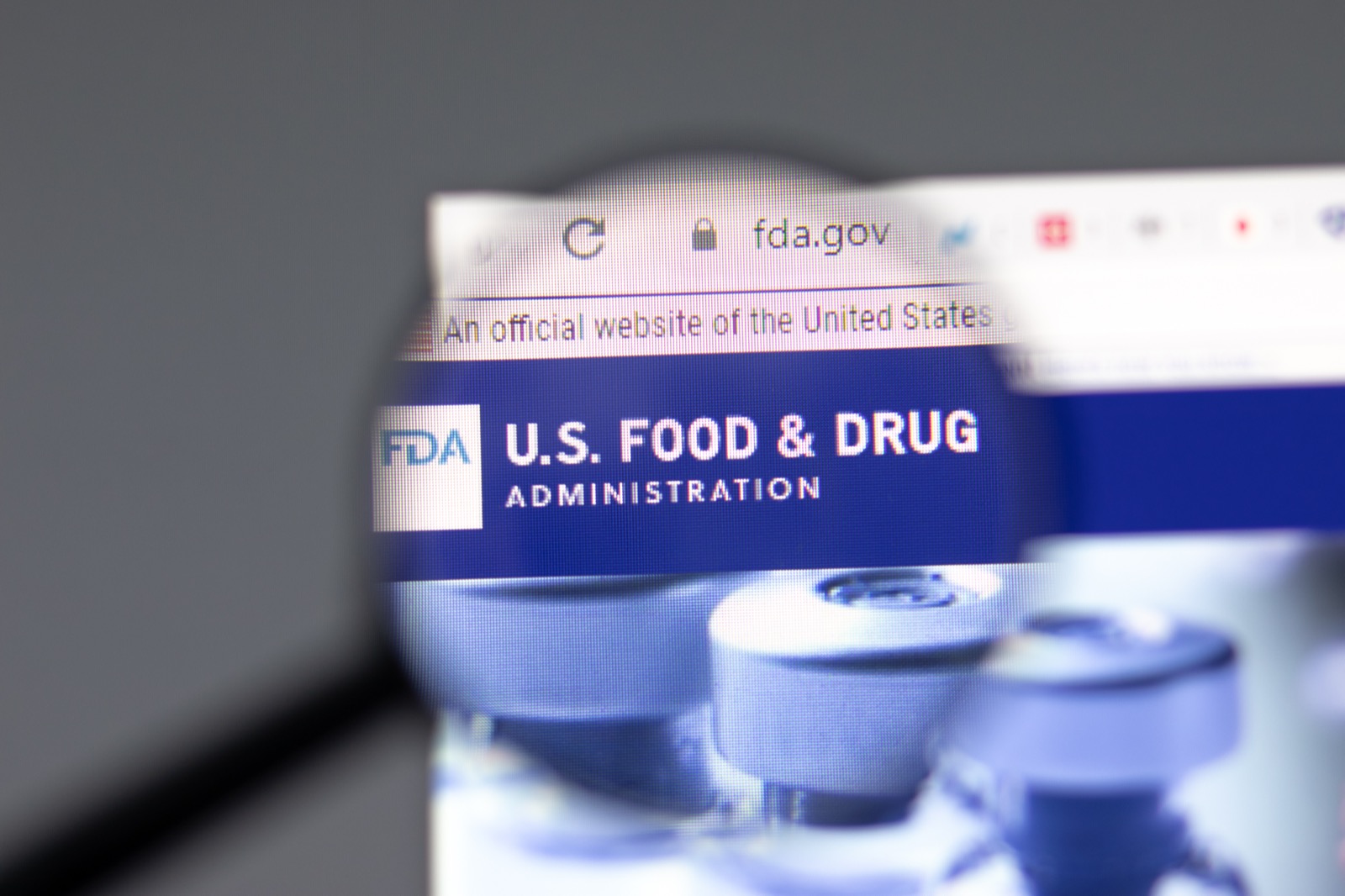 The FDA.gov website displayed through a magnifying glass, emphasizing regulatory documentation and oversight